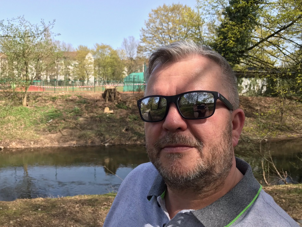 Mann am Flussufer mit Sonnenbrille