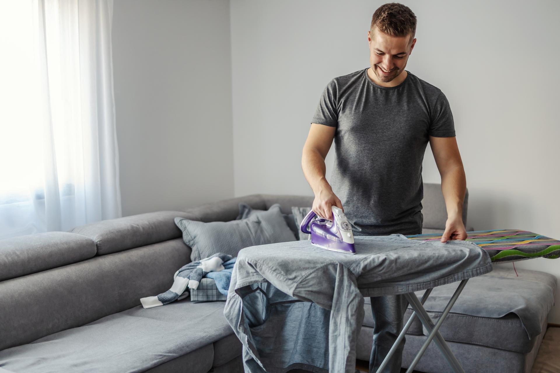 Mann bügelt ein Shirt